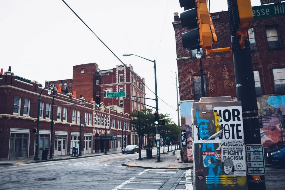 Picture of an Atlanta street corner, with posters on the wall that say "Fight racism"